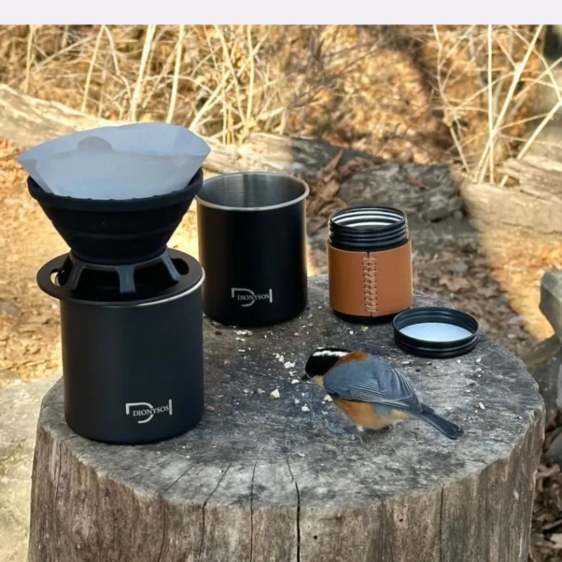 Outdoor coffee setup with a bird on a tree stump