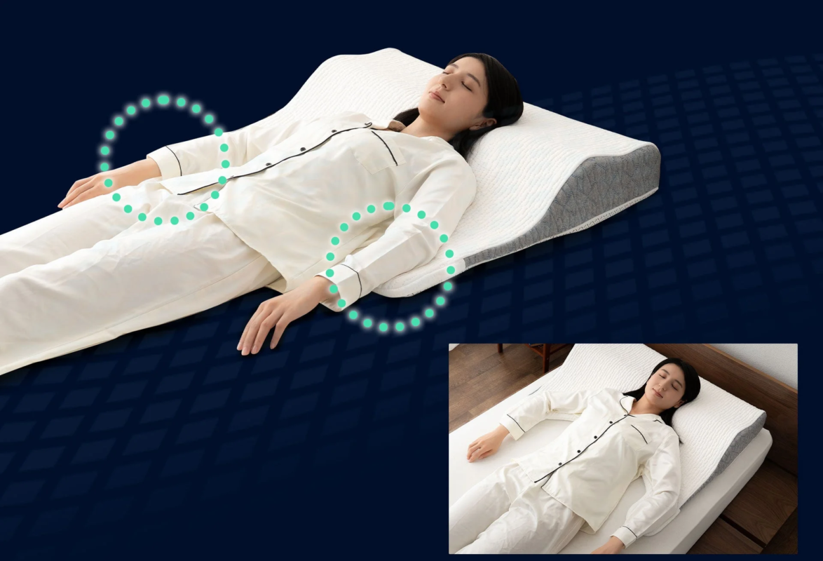 A woman lying on her back on a special pillow and mattress, with arm supports designed for comfort and relaxation.