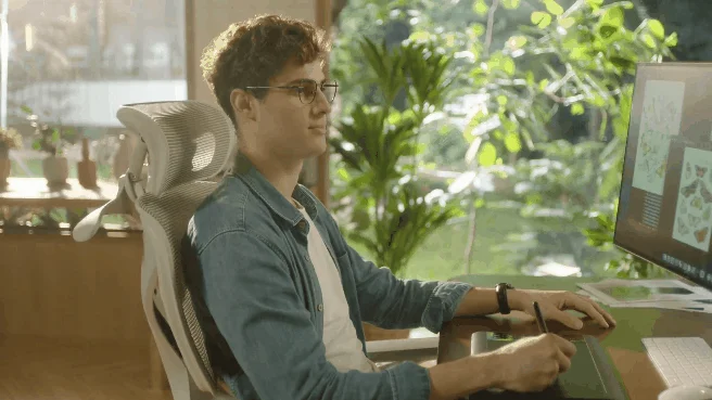 Man working at a desk with COFO Chair Pro 2, showing recline and armrests