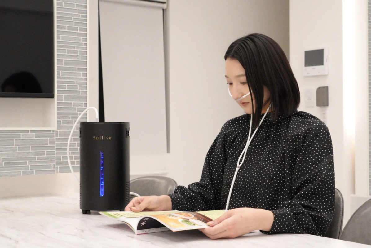 Woman using Suilive hydrogen inhaler at home