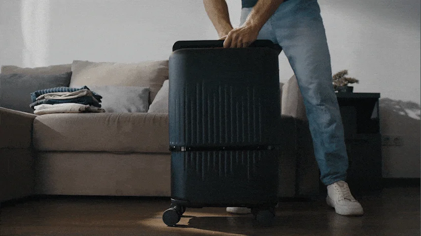 Man operating transformable VELO suitcase in a room