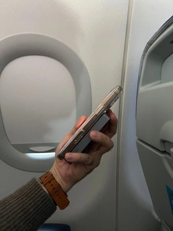 Person holding smartphone in airplane