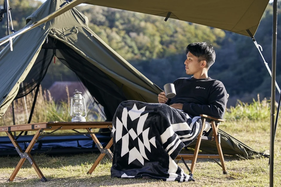 Man relaxing in a tent with a PowerArQ electric blanket