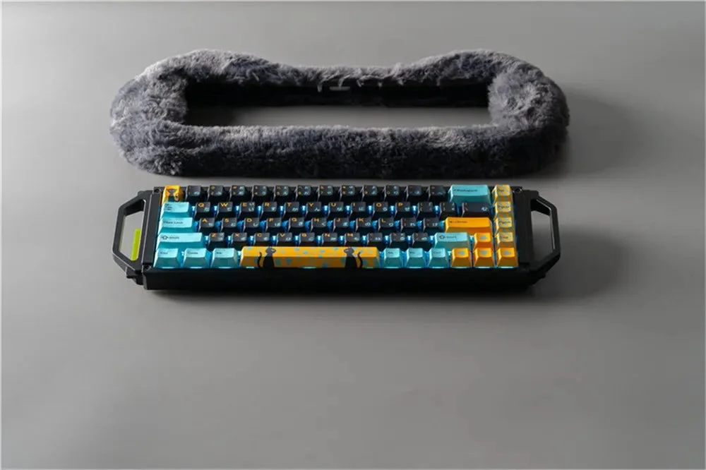 A mechanical keyboard with colorful keycaps and a grey base, featuring a cat silhouette on the spacebar and a fluffy grey object at the top.