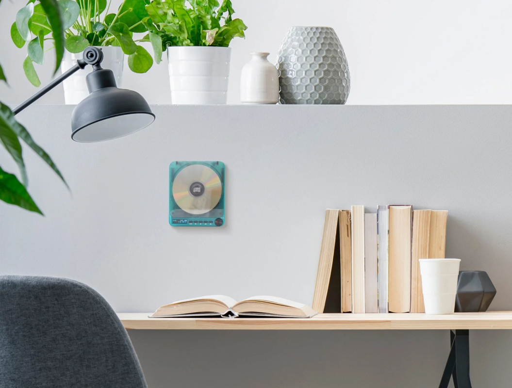 Modern study desk with green plants and transparent CD player