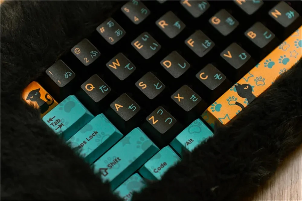 A top-down view of the PETBRICK 65 keyboard, showing a black fluffy case surrounding orange and blue keycaps with Japanese and English legends.