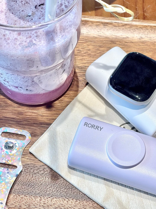 Smoothie, smartwatch, and charger on a wooden table