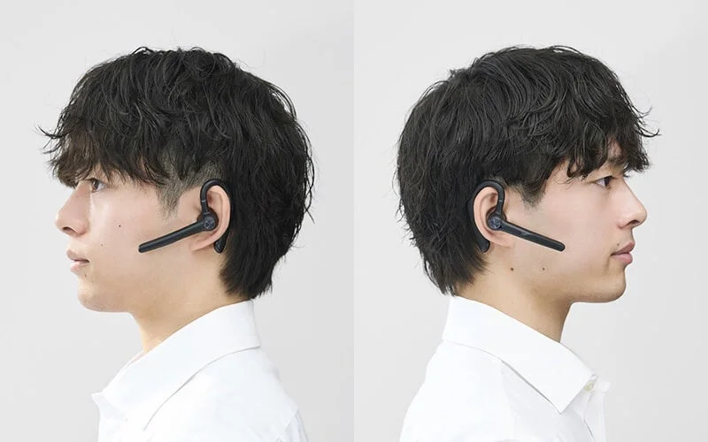 Side profile of a man wearing a Bluetooth headset on both his left and right ears, demonstrating ambidextrous wearing