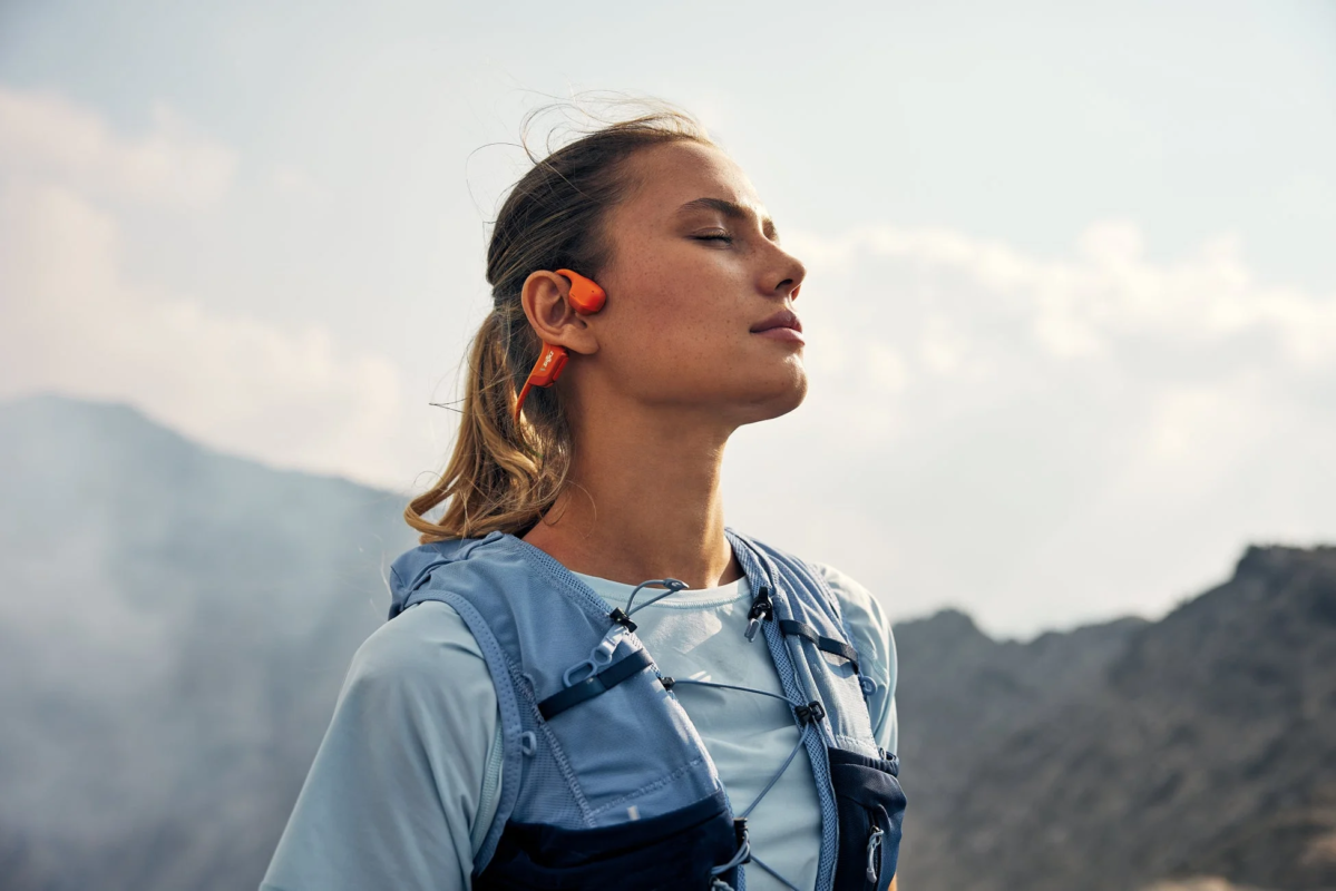 Woman wearing Shokz earphones outdoors