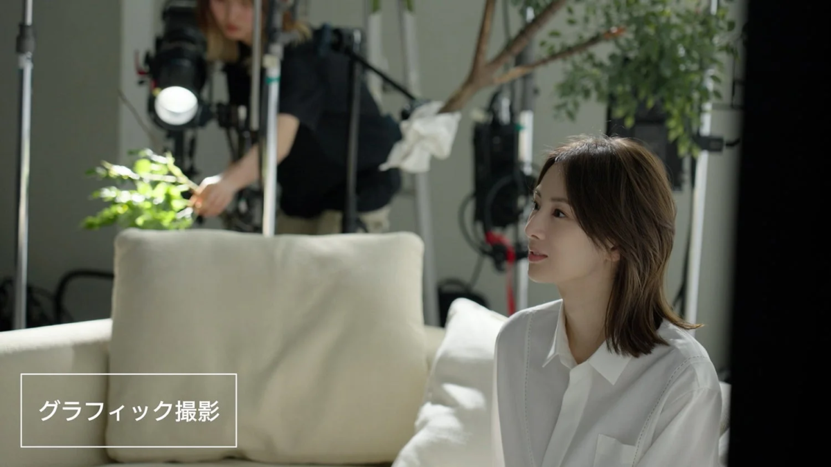 A studio setup for a graphic shoot with a woman on a sofa and crew