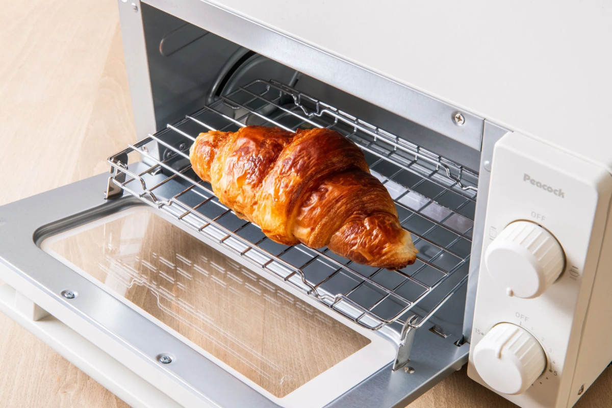 Croissant baking inside a white oven toaster