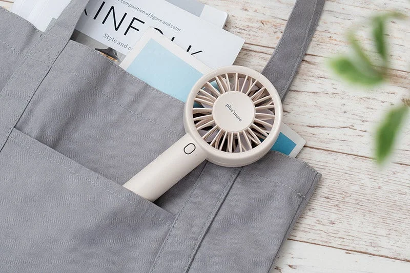 White handy fan in a tote bag pocket