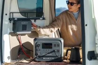 Woman using an electric kettle with a BLUETTI portable power station in a van