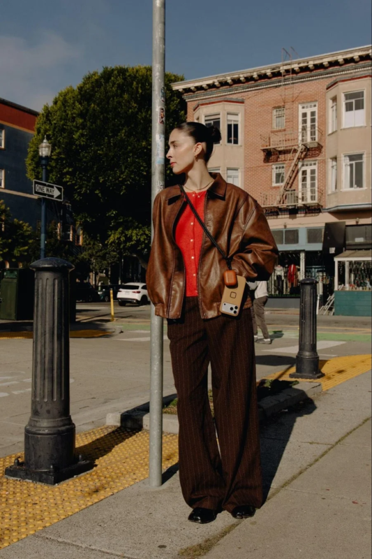 Woman with a smartphone on a strap in a city street