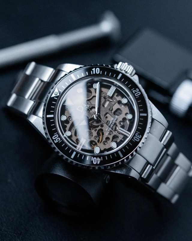 Close-up of a sophisticated automatic skeleton diver's watch with a black dial