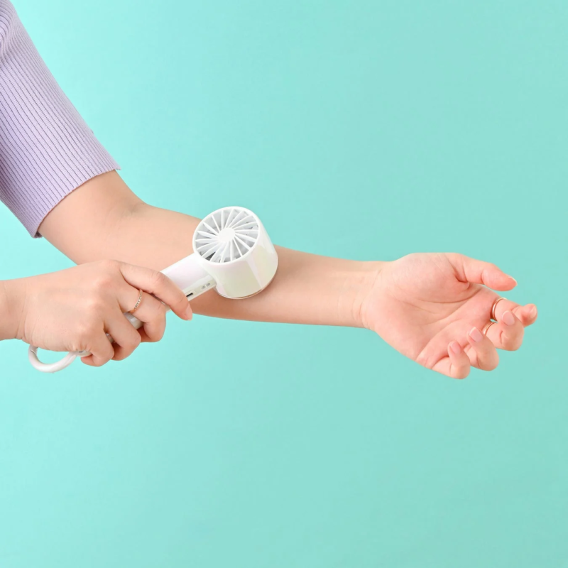 Woman cooling arm with white handy fan