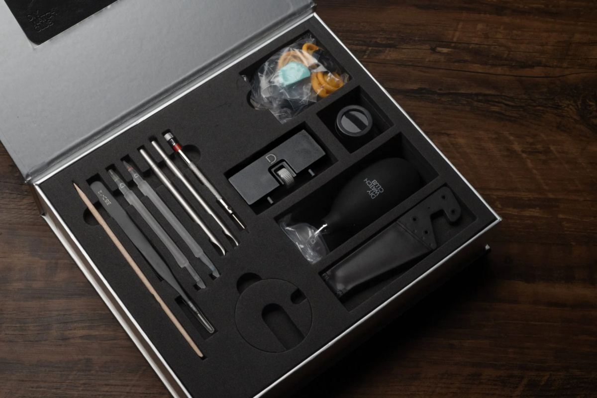 An opened box containing a comprehensive set of watch repair and assembly tools