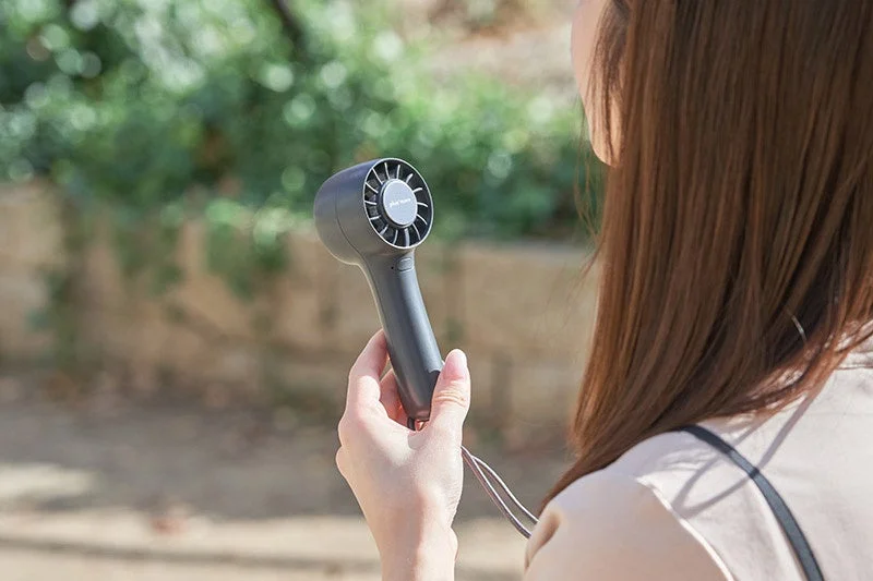 Woman Using Fan Outdoors