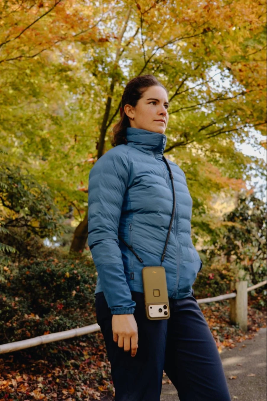 Woman with a smartphone on a strap in an autumn setting