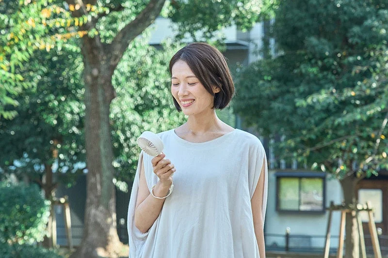 Woman smiling with a handy fan