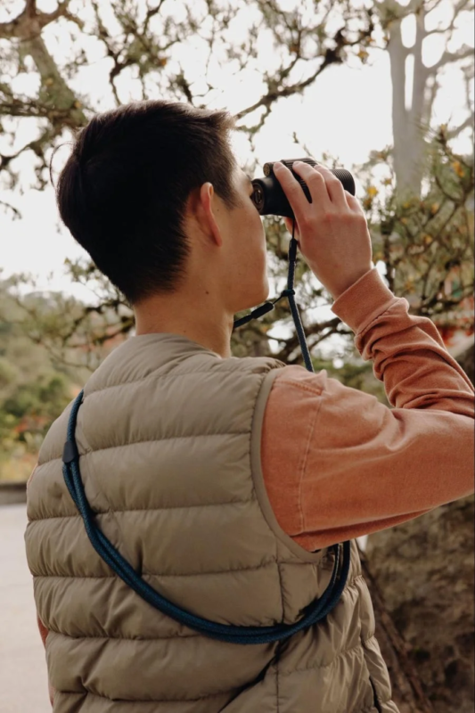 Man with binoculars, showing strap usage