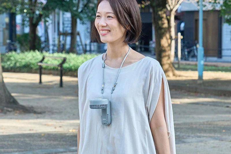 Woman using fan with neck strap