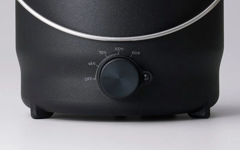 Close-up of the operation panel of a black cooking appliance, showing a dial for temperature settings.