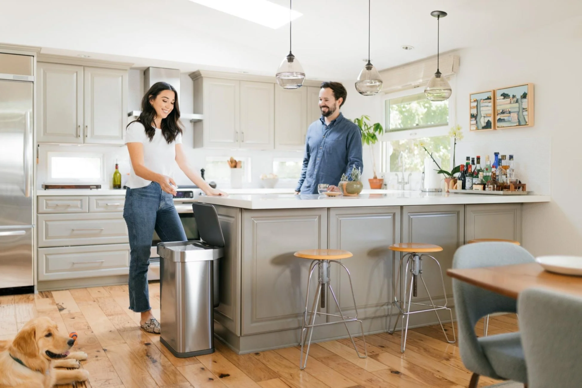 Couple and dog in a modern kitchen with a sensor can
