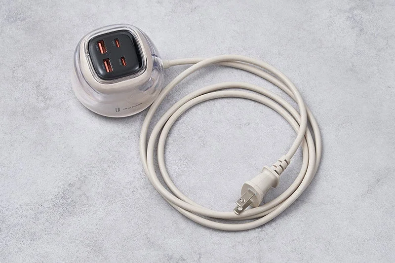 A rounded power strip with USB charging ports and AC outlets, featuring a white coiled power cord.