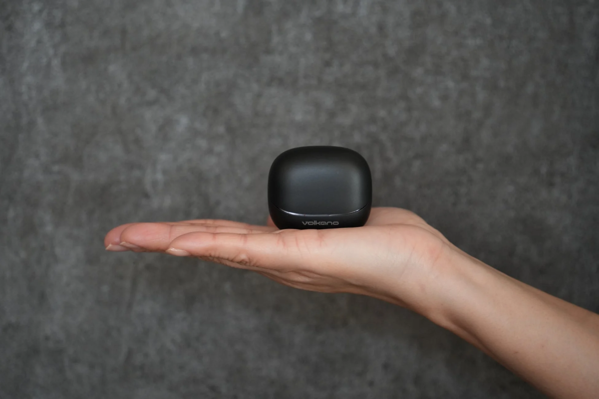 A hand holding the sleek, black charging case of the Volkano VK-ASPEN earphones.
