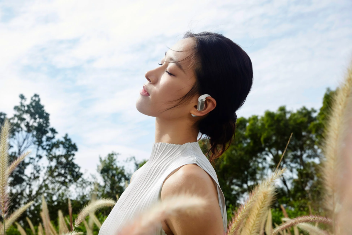 Woman enjoying music outdoors with OpenFit Pro