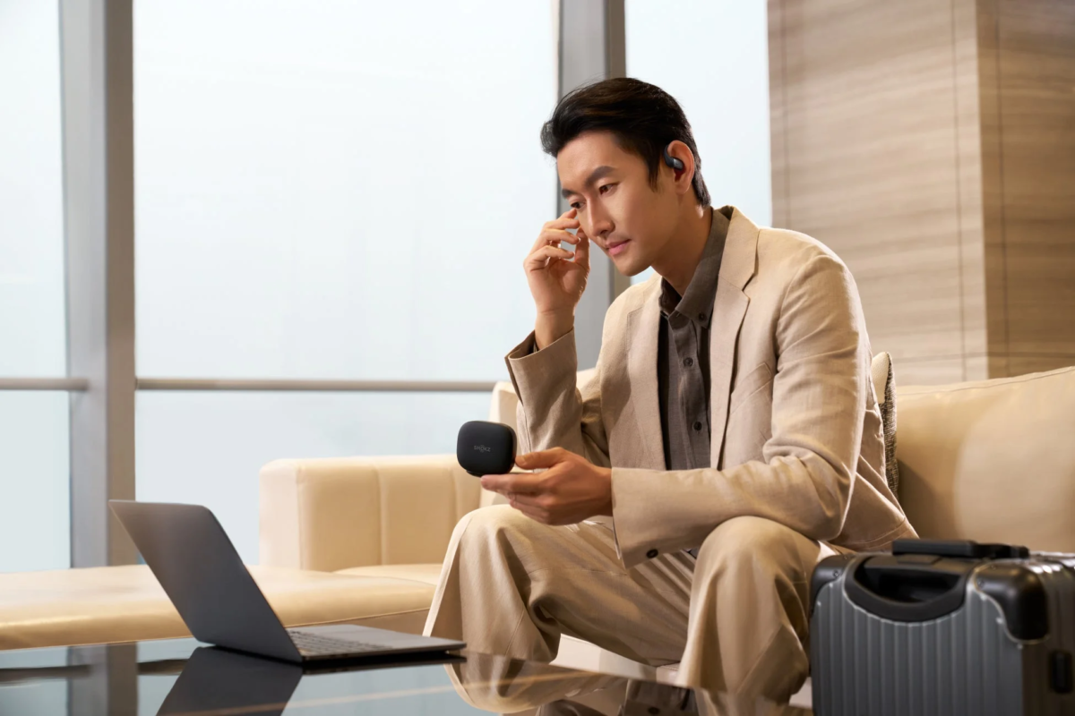 Man using OpenFit Pro with laptop