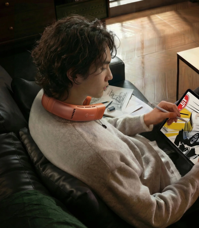 Man Using Neck Fan on Sofa