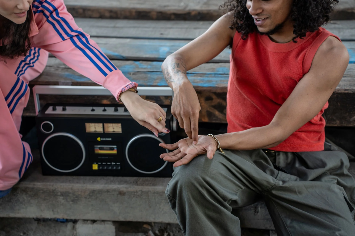 People touching boombox