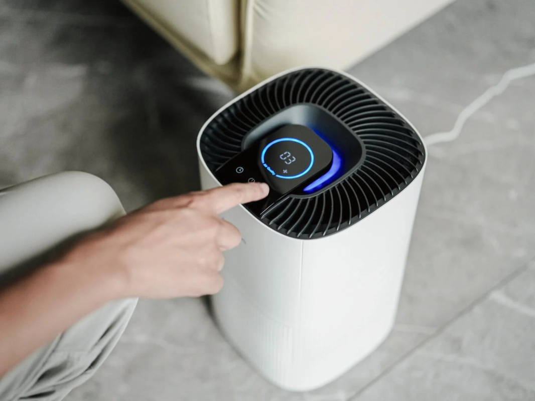 Hand interacting with air purifier display