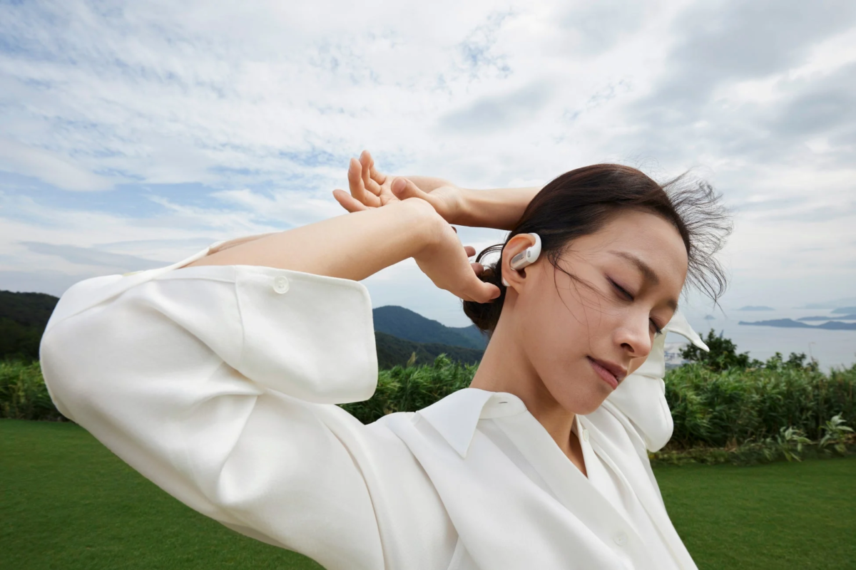 Woman relaxing outdoors with OpenFit Pro