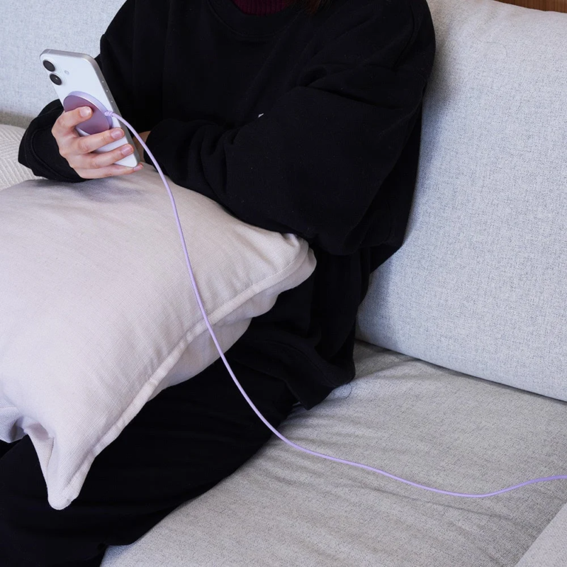 Person on sofa with phone charging