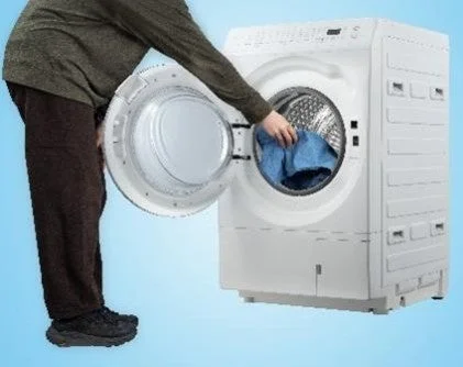 Person loading laundry into the washing machine