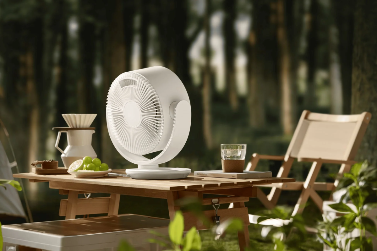 White fan on a wooden table in a campsite