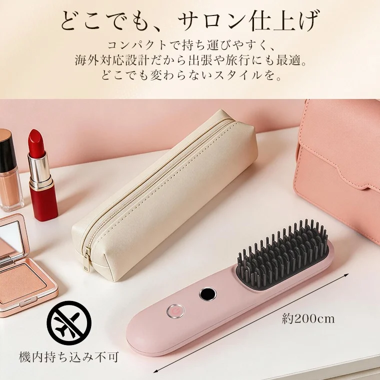 A compact pink hair iron brush surrounded by makeup, indicating its portability for travel and on-the-go styling.
