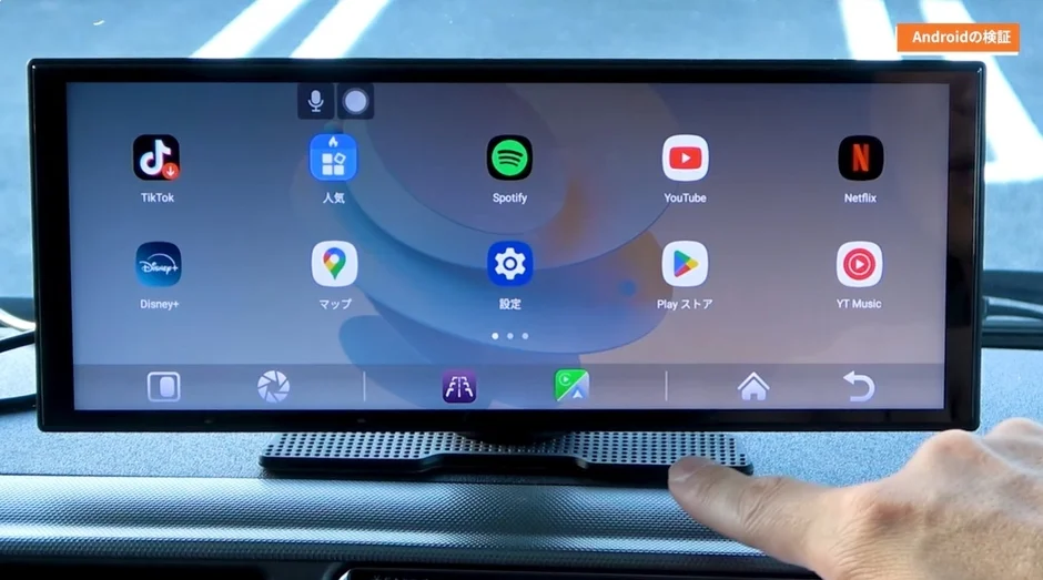 Car display showing TikTok, Disney+, Spotify, YouTube, Netflix, and other popular apps, with a hand reaching towards the screen.