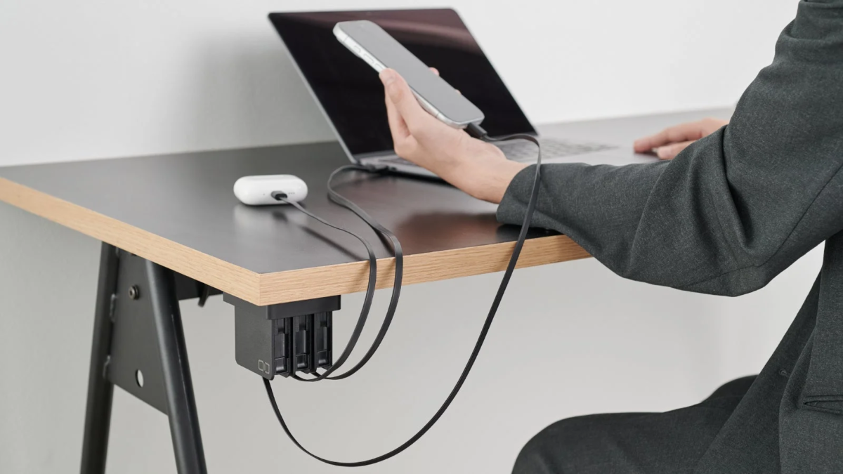 Hand using Cerberus to charge multiple devices