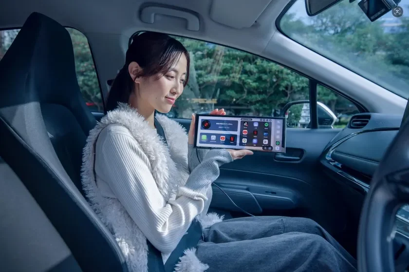 Woman holding Ottocast Screen AI in car
