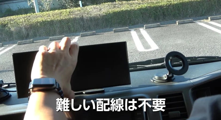 A hand adjusting a device on a car dashboard, with text indicating "No complicated wiring needed."