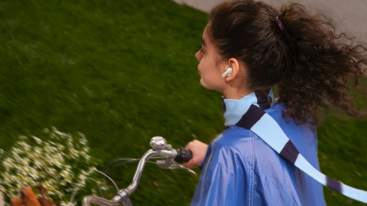 Person cycling with earbuds, representing call quality/outdoor use