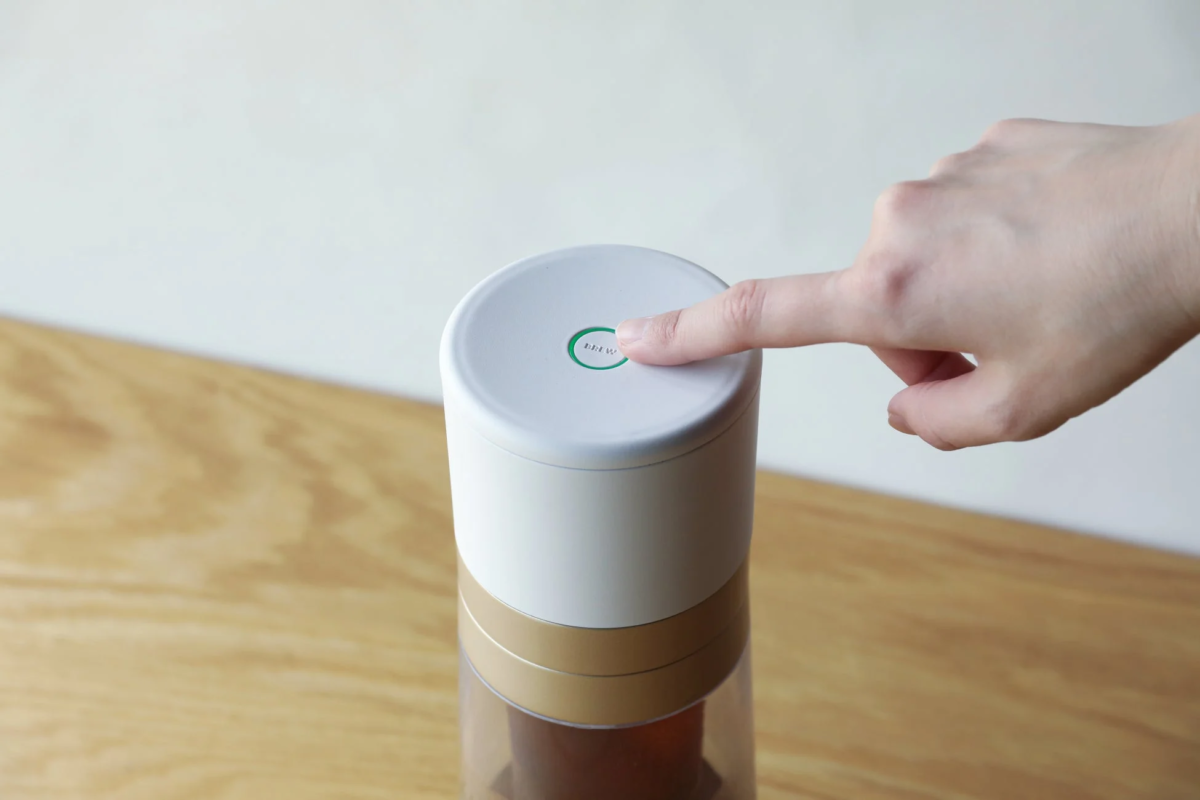 Pressing the brew button on the coffee maker
