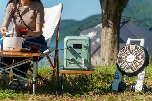 Woman using AORA 100 mini at campsite