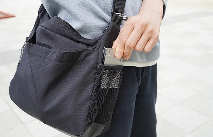 Man taking camera out of shoulder bag