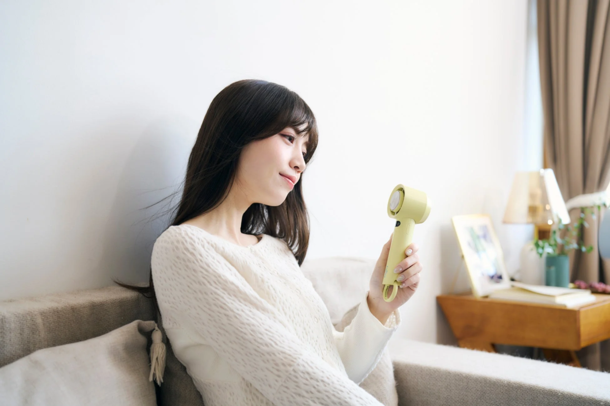 Woman using iFan Freeze3 on sofa