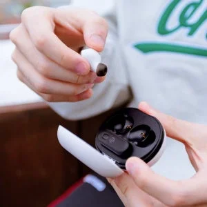 White Arctis GameBuds in hand